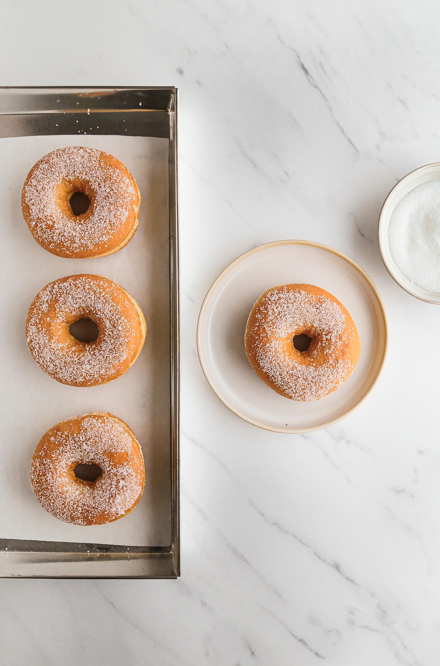 Stil life con ambientazione do donuts su sfondo in vinile effetto marmo, moderno, bianco, e neutro. 