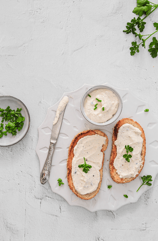 Scatto flatlay di piatto bianco ocn bruschette al formaggio su sfondo materico bianco